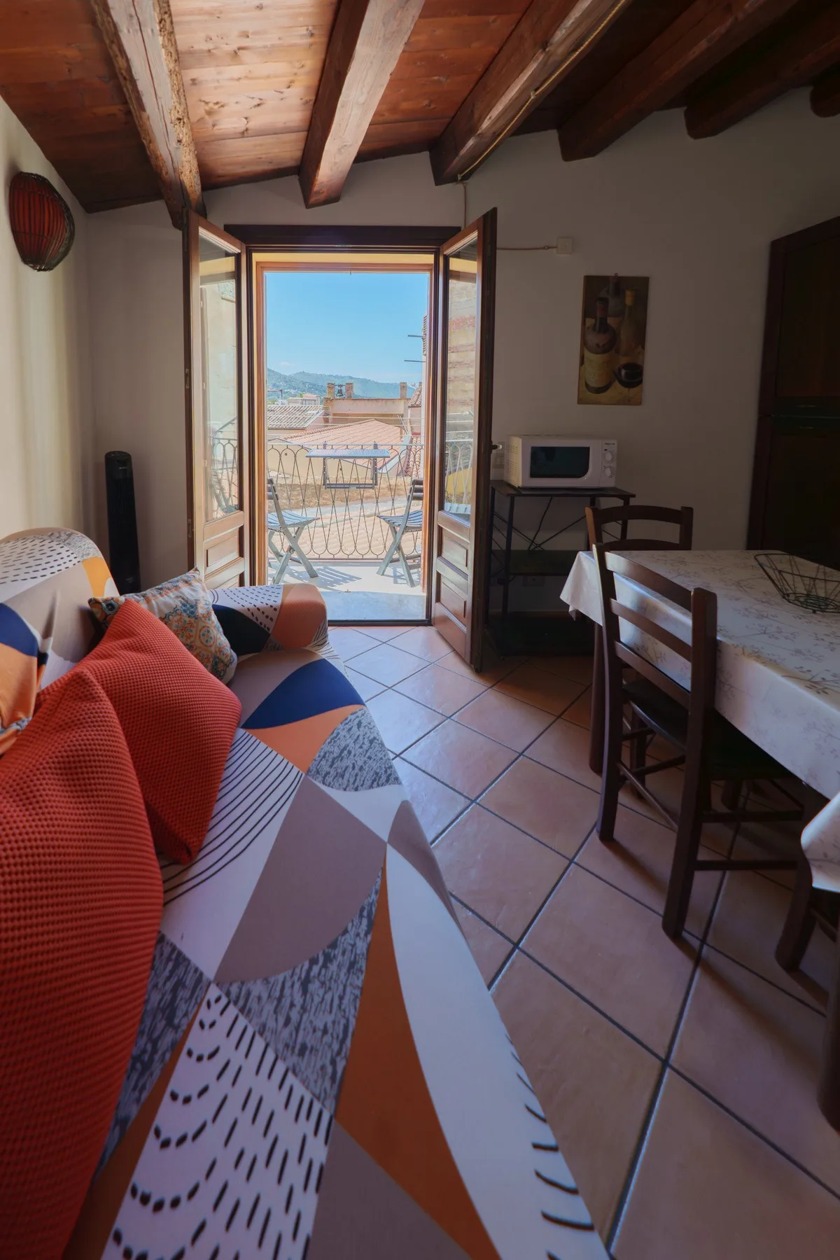 Una zona de comedor y estar da a un balcón a través de puertas de cristal.