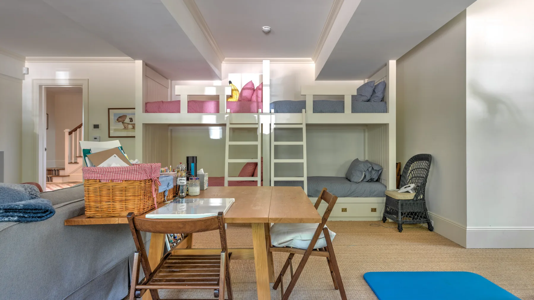 Una habitación amueblada con una mesa de comedor, asientos y almacenamiento integrado.