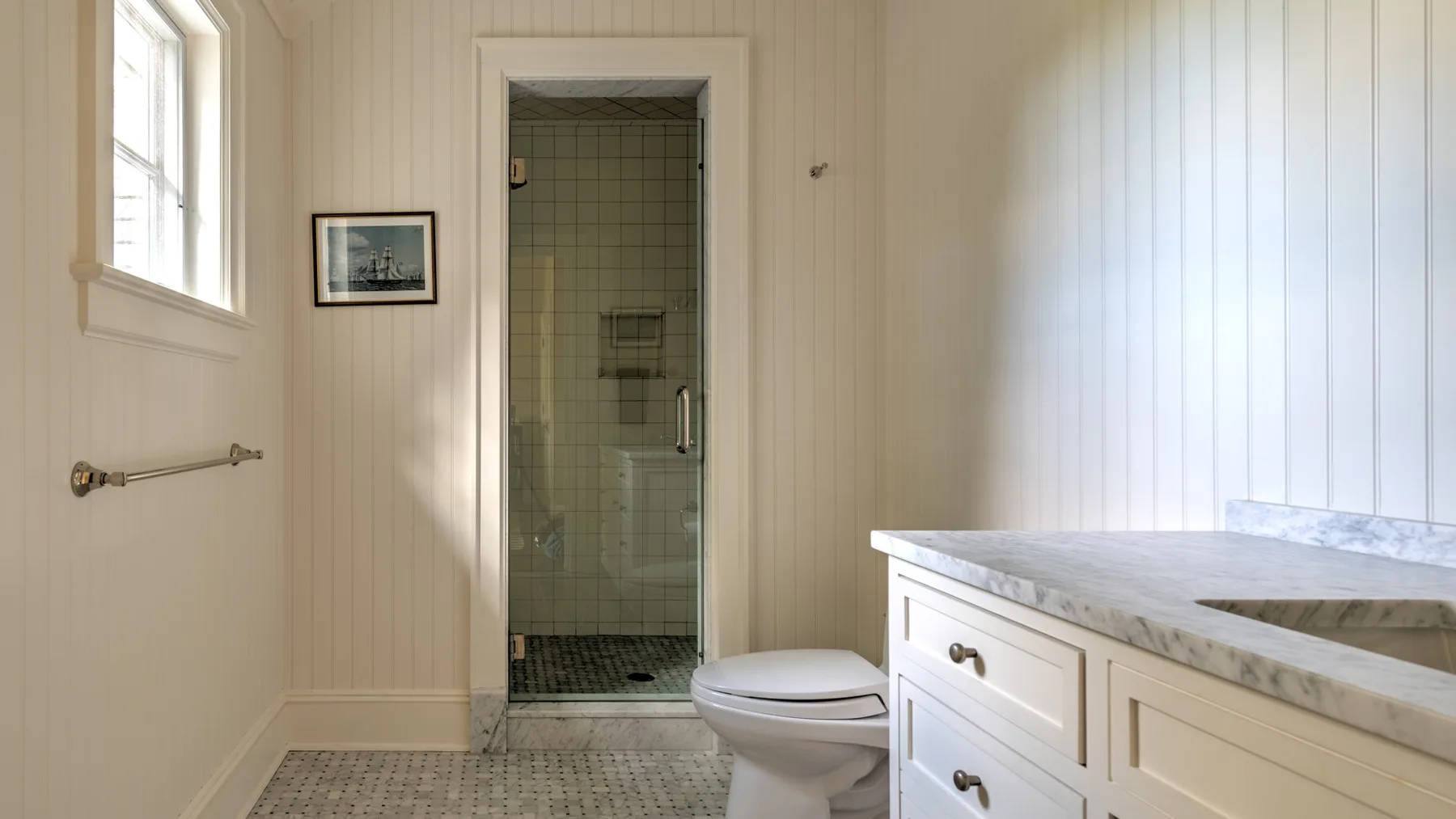 Un baño con ducha de azulejos, inodoro y tocador.