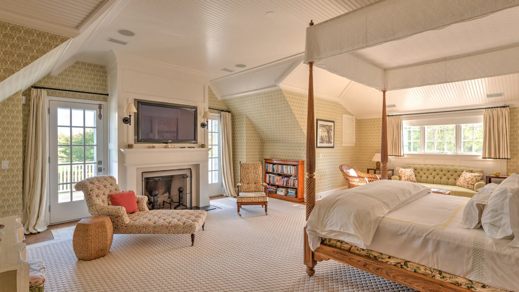 Dormitorio con cama con dosel, zona de estar y chimenea.