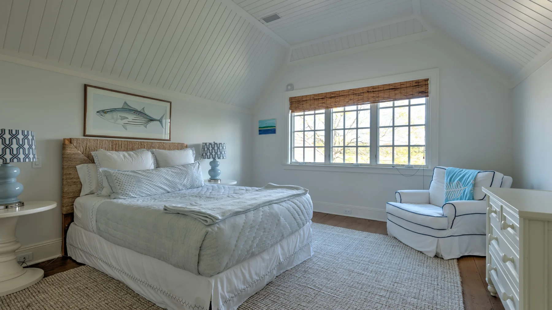 Un dormitorio luminoso con una cama grande y una ventana con vistas al exterior.