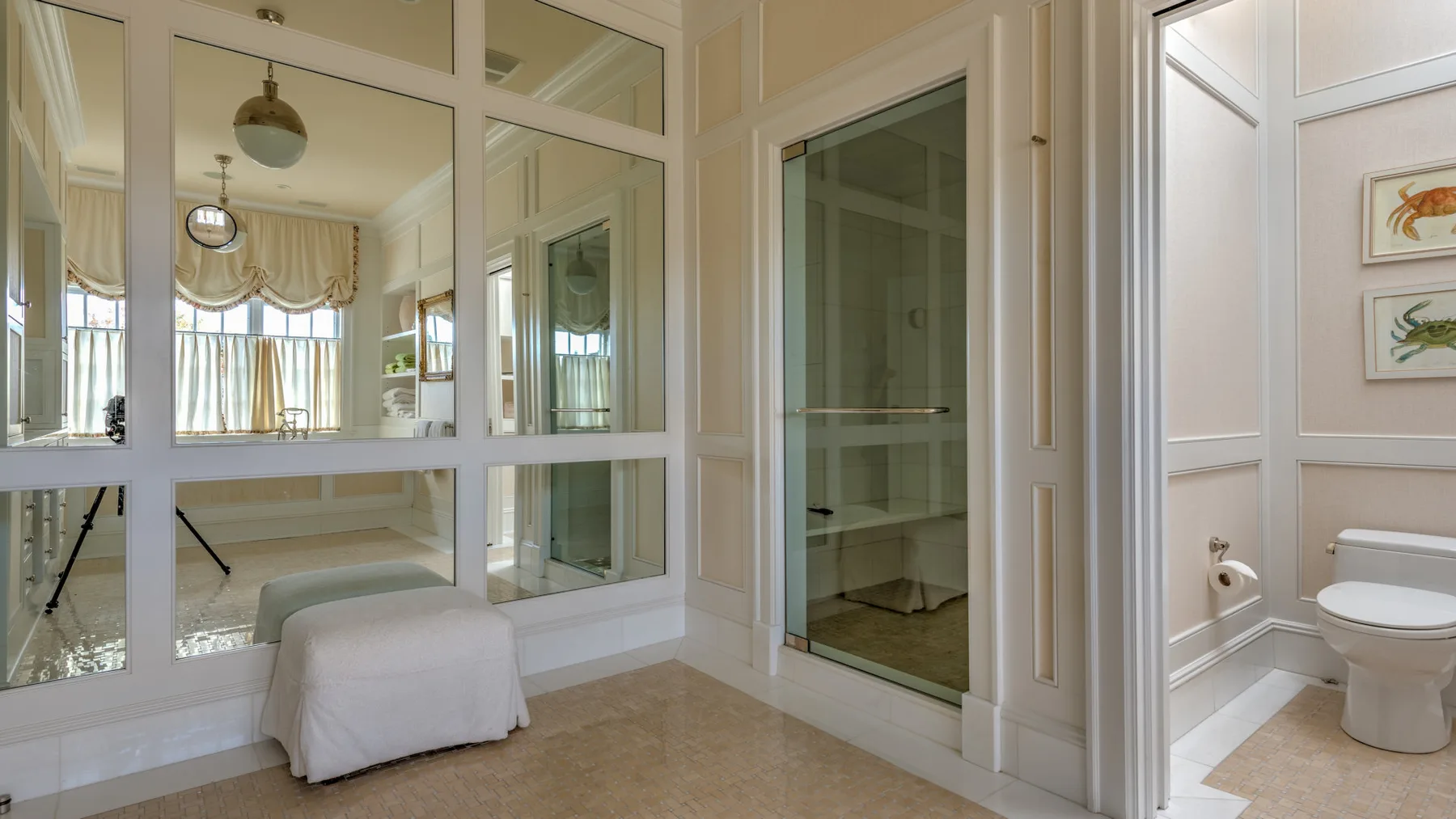 Un interior luminoso con mamparas de vidrio, un asiento cubierto y un baño contiguo.