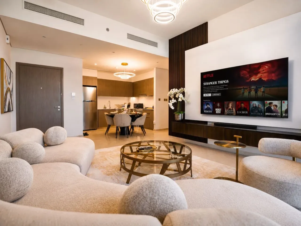 A bright living room with curved seating and a large television.