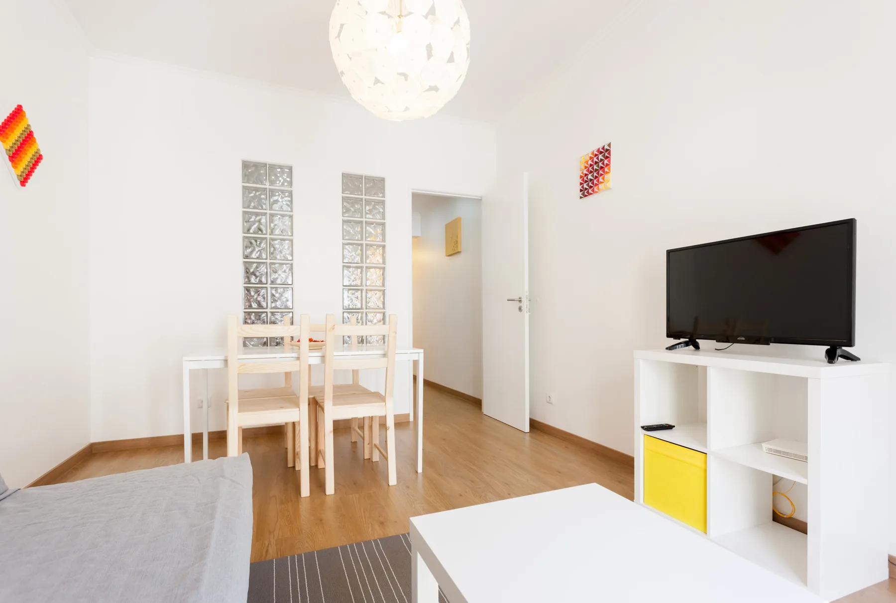 A bright living and dining area with a television and dining table.