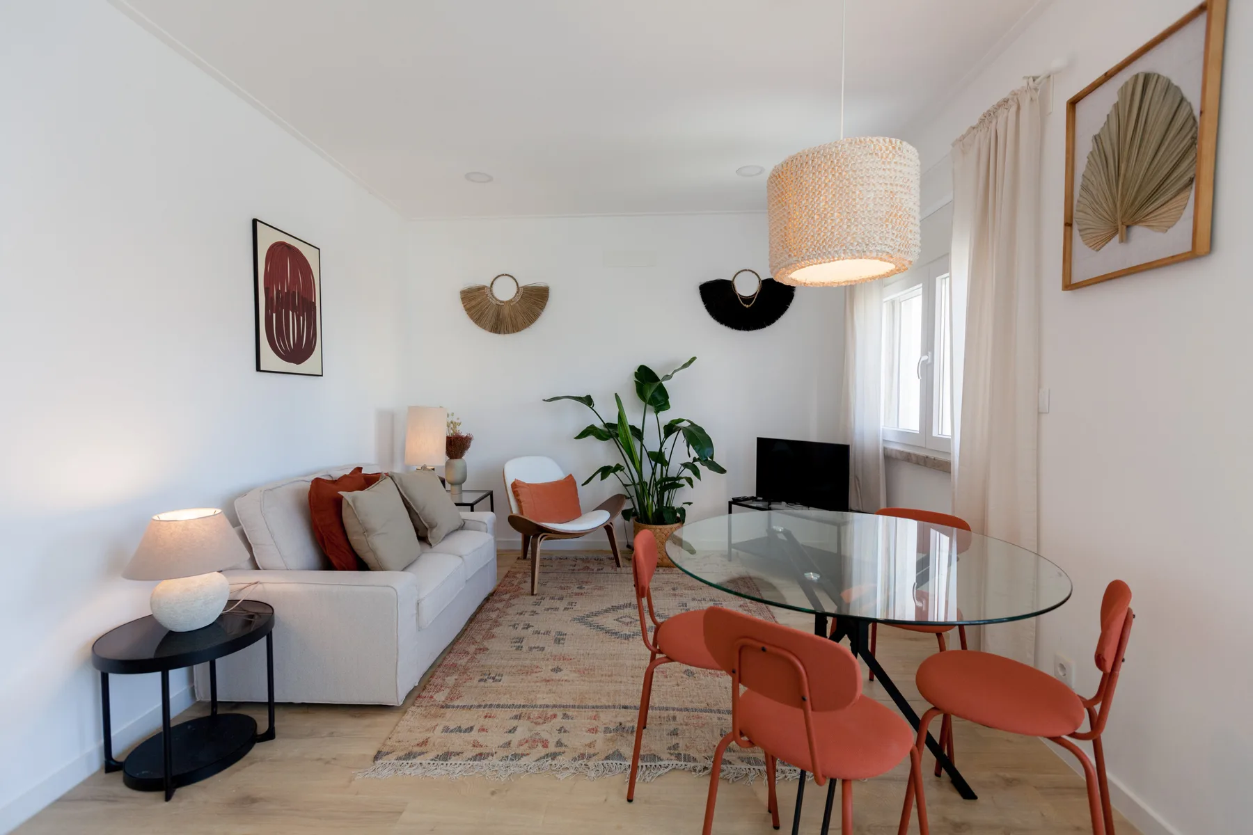 Una sala luminosa con asientos alrededor de una mesa de comedor de vidrio.