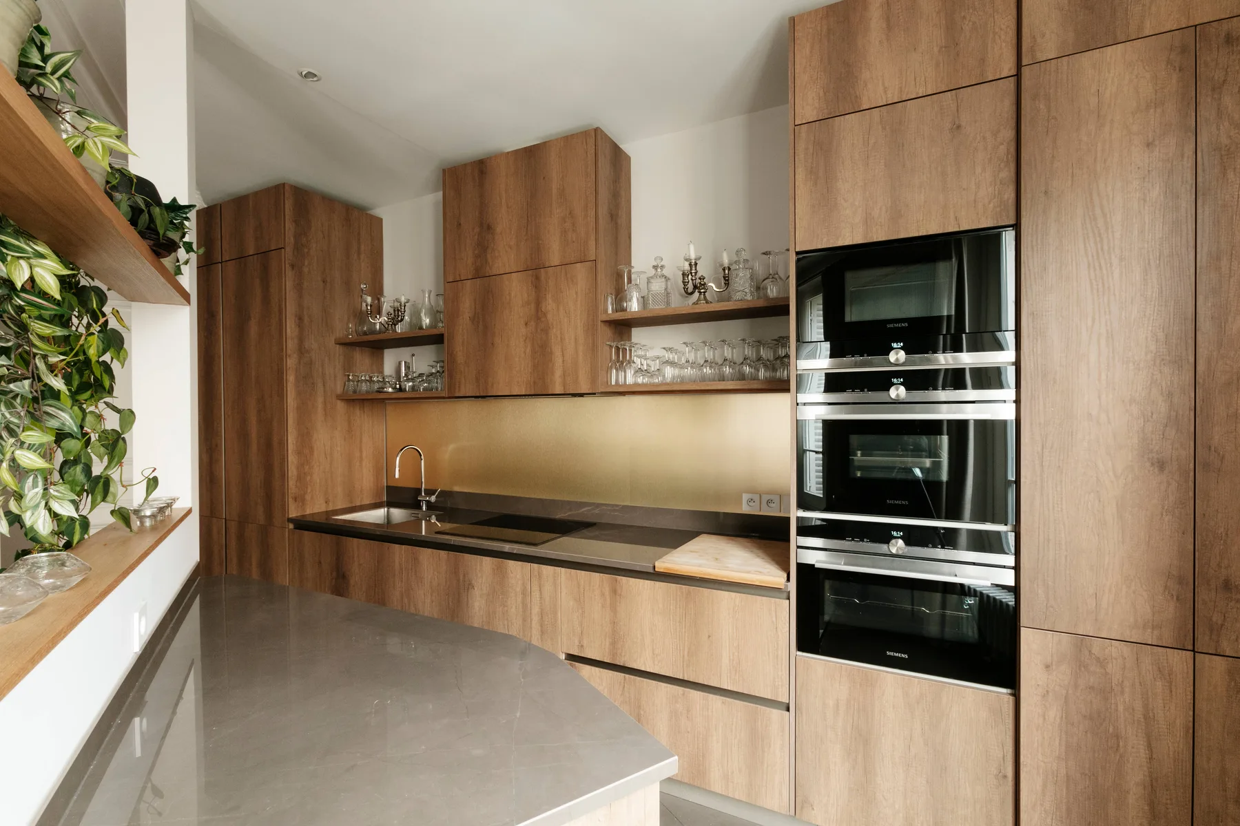 Una cocina moderna con gabinetes de madera, una encimera larga y electrodomésticos integrados.