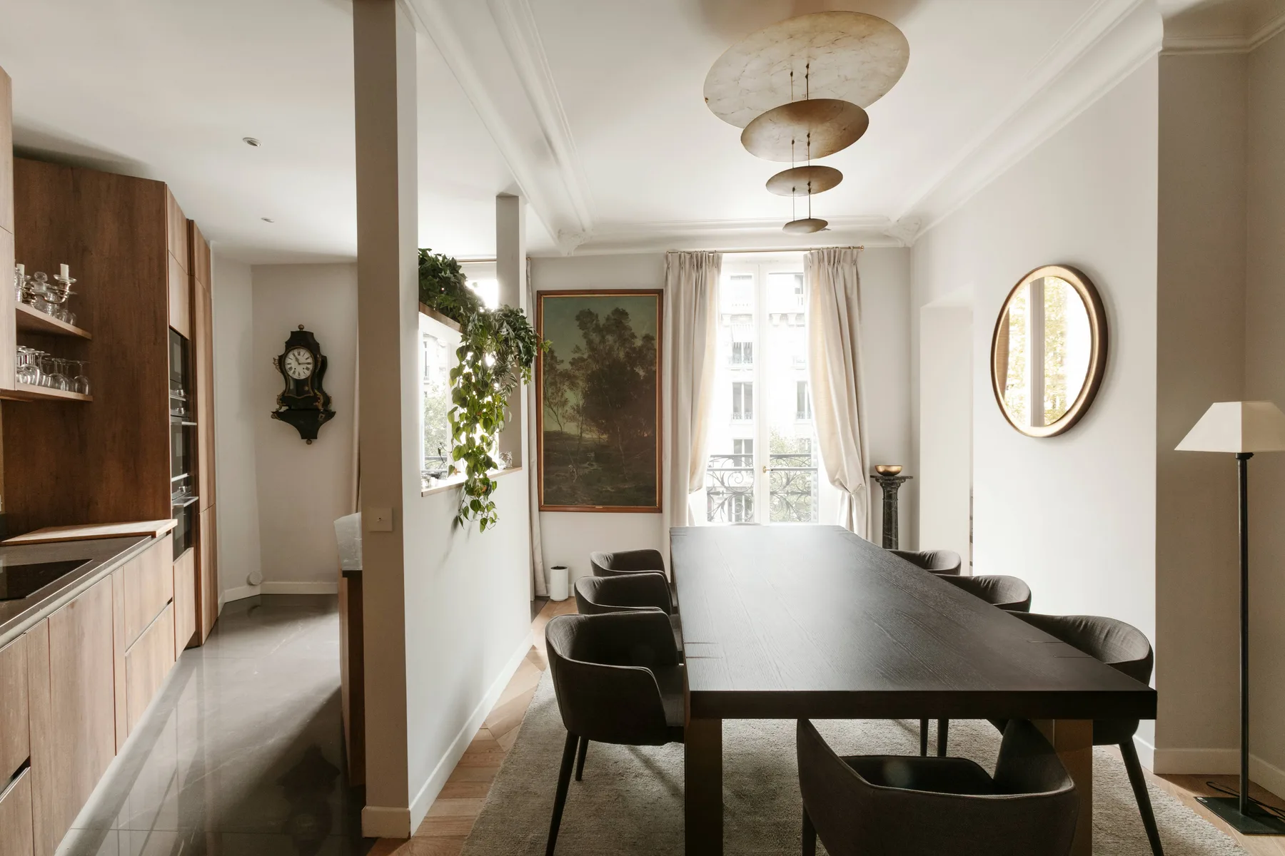 Un comedor luminoso con una mesa larga, asientos y grandes ventanas.