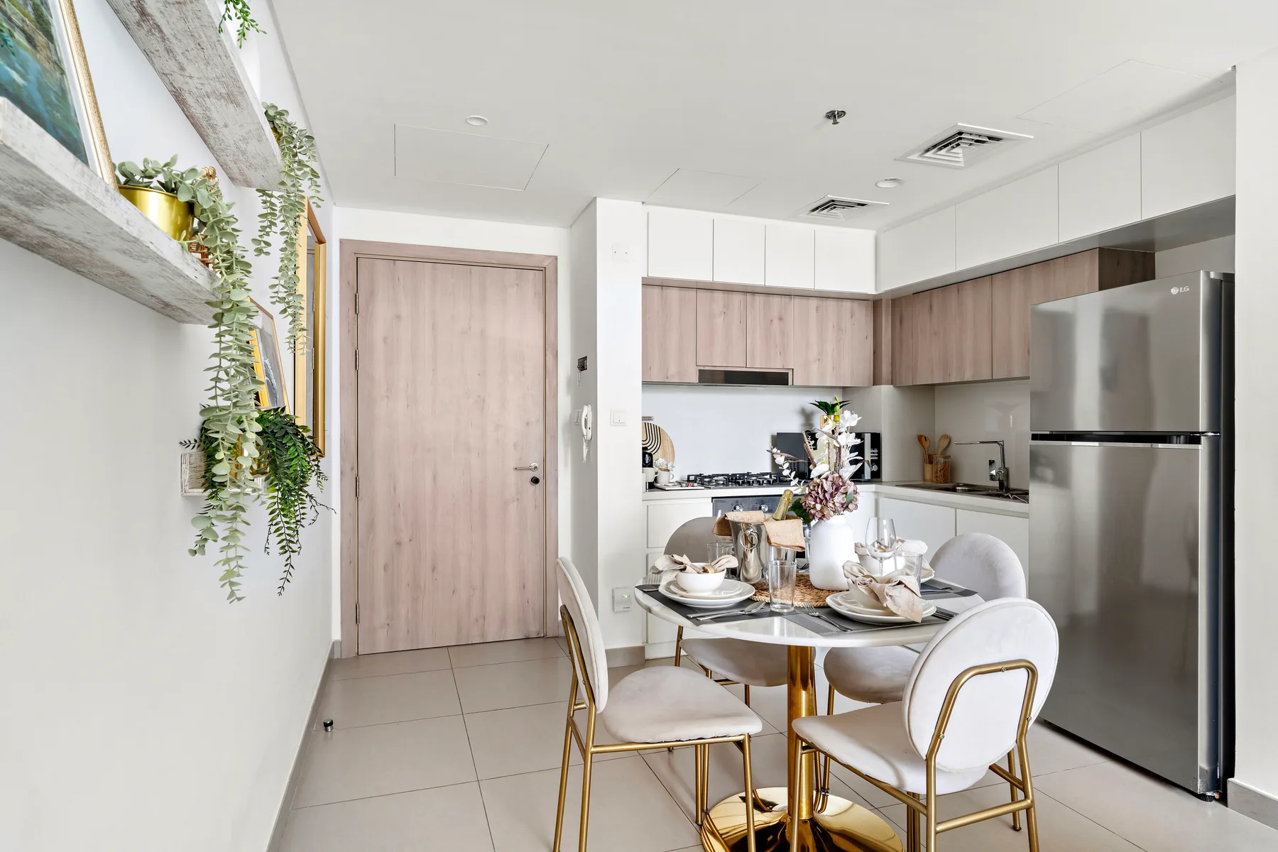 A bright kitchen and dining area with cabinetry and a set dining table.