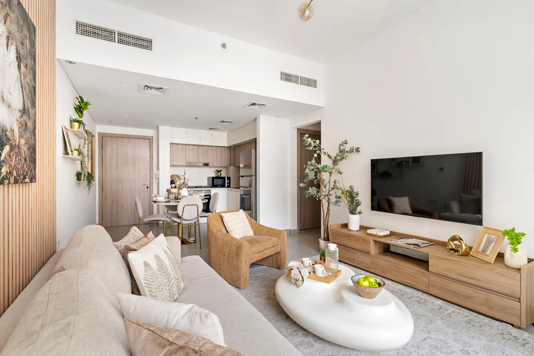 A bright living room with seating, a coffee table, and a television.