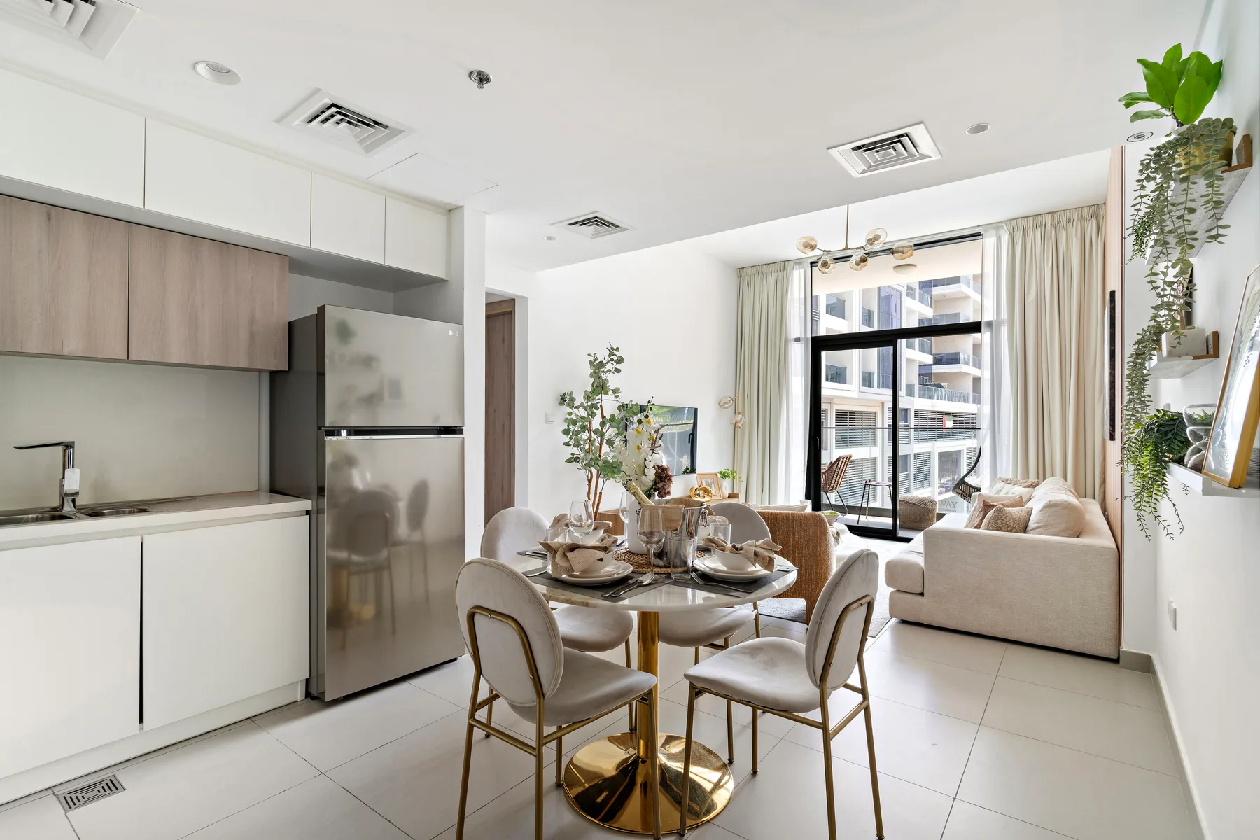 A bright open-plan living and dining area with a compact kitchen and large windows.