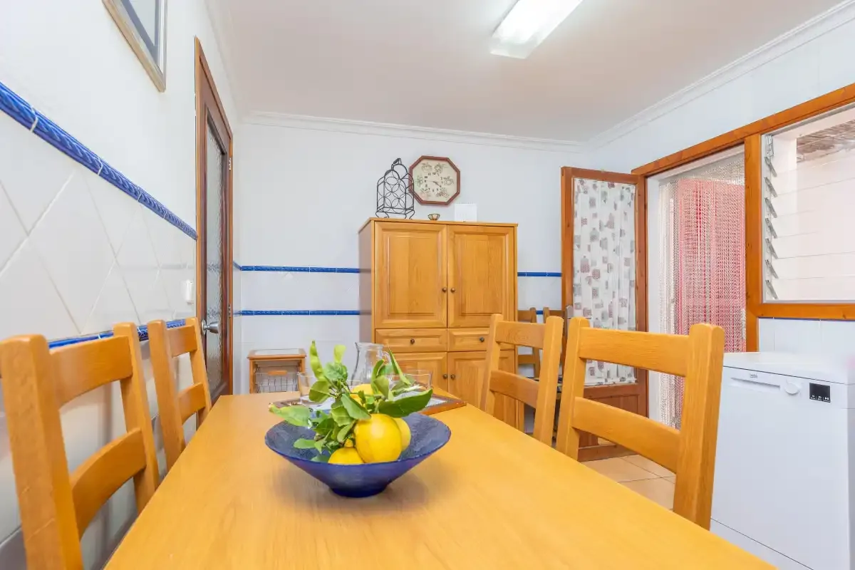 Comedor con una mesa de madera y un cuenco de fruta.