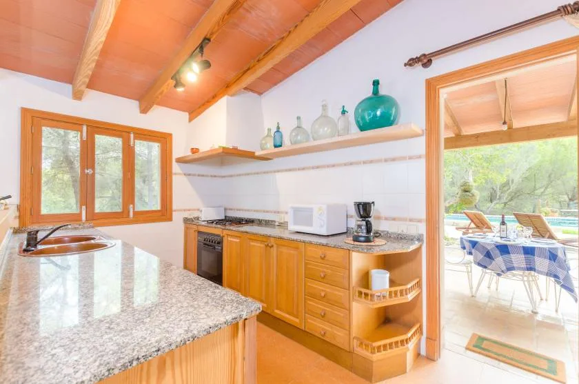 A bright kitchen with wooden cabinets and a countertop.
