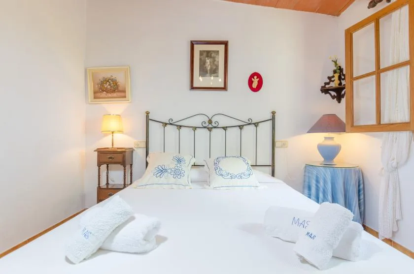 A bedroom with a metal bed, white linens, and bedside tables.