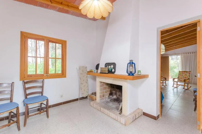 A bright living room with a brick fireplace and wooden-framed window.
