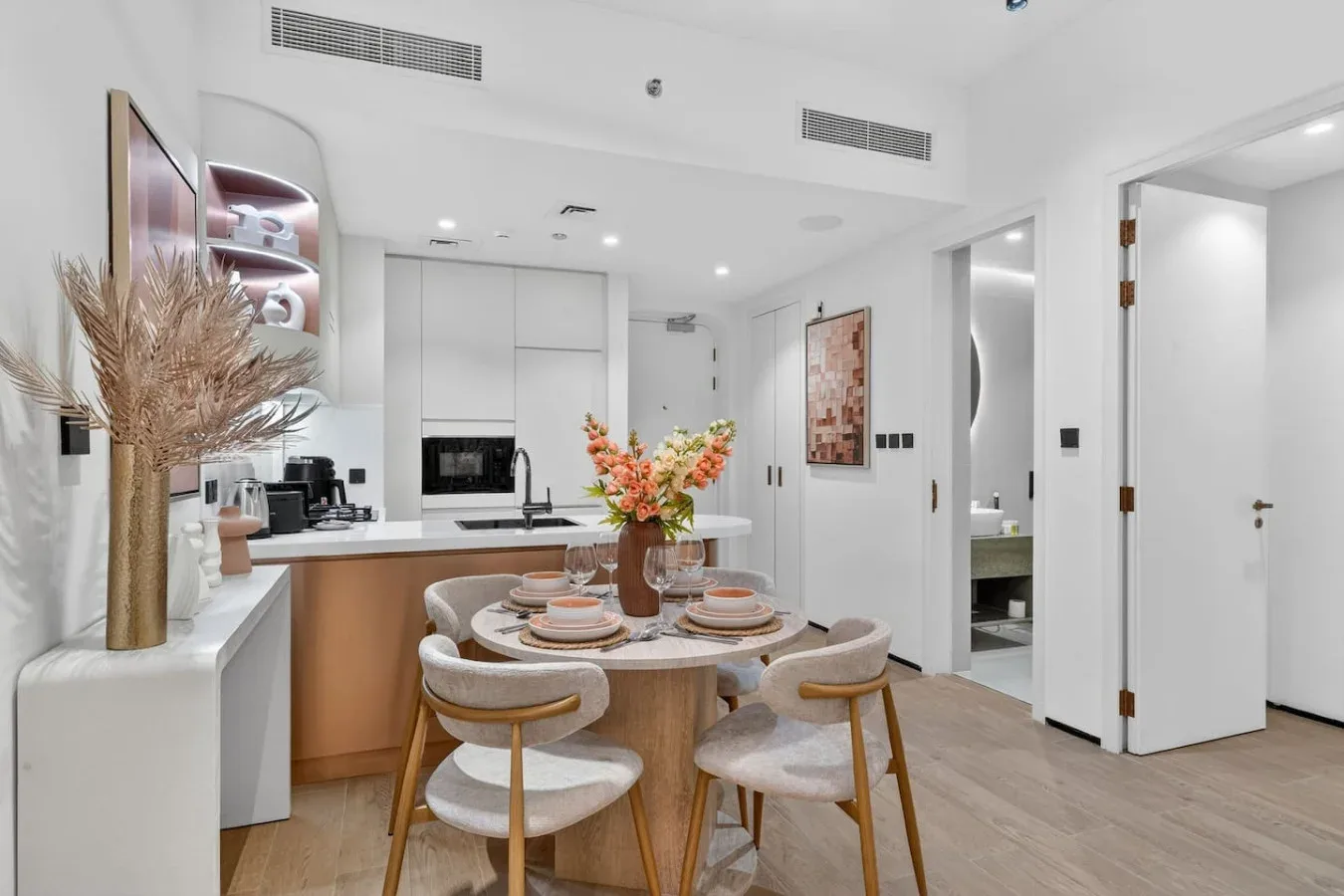 Un comedor luminoso con una mesa redonda junto a una cocina compacta.
