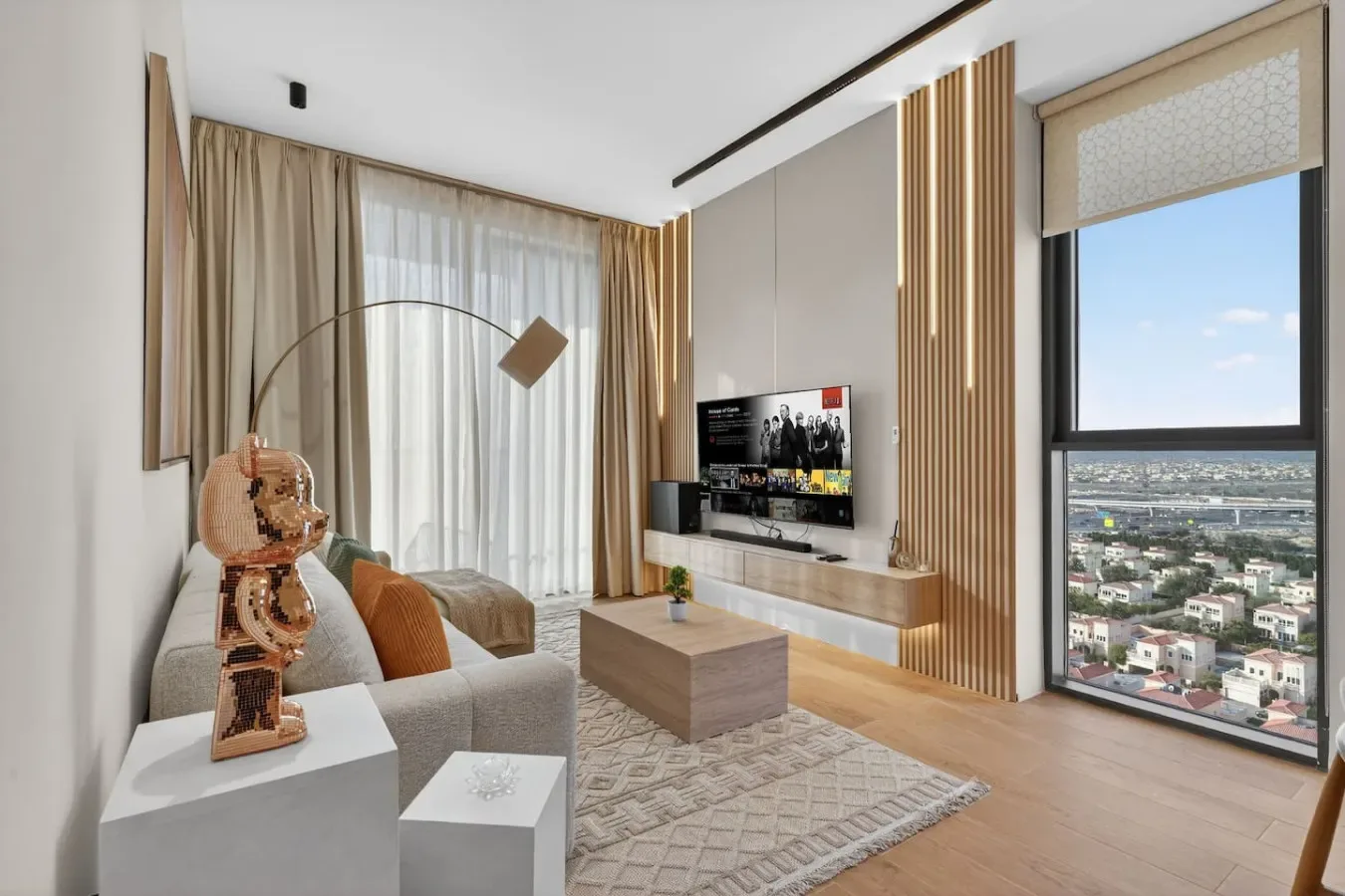 Una sala luminosa con asientos, una mesa de centro y una gran ventana con vistas a la ciudad.