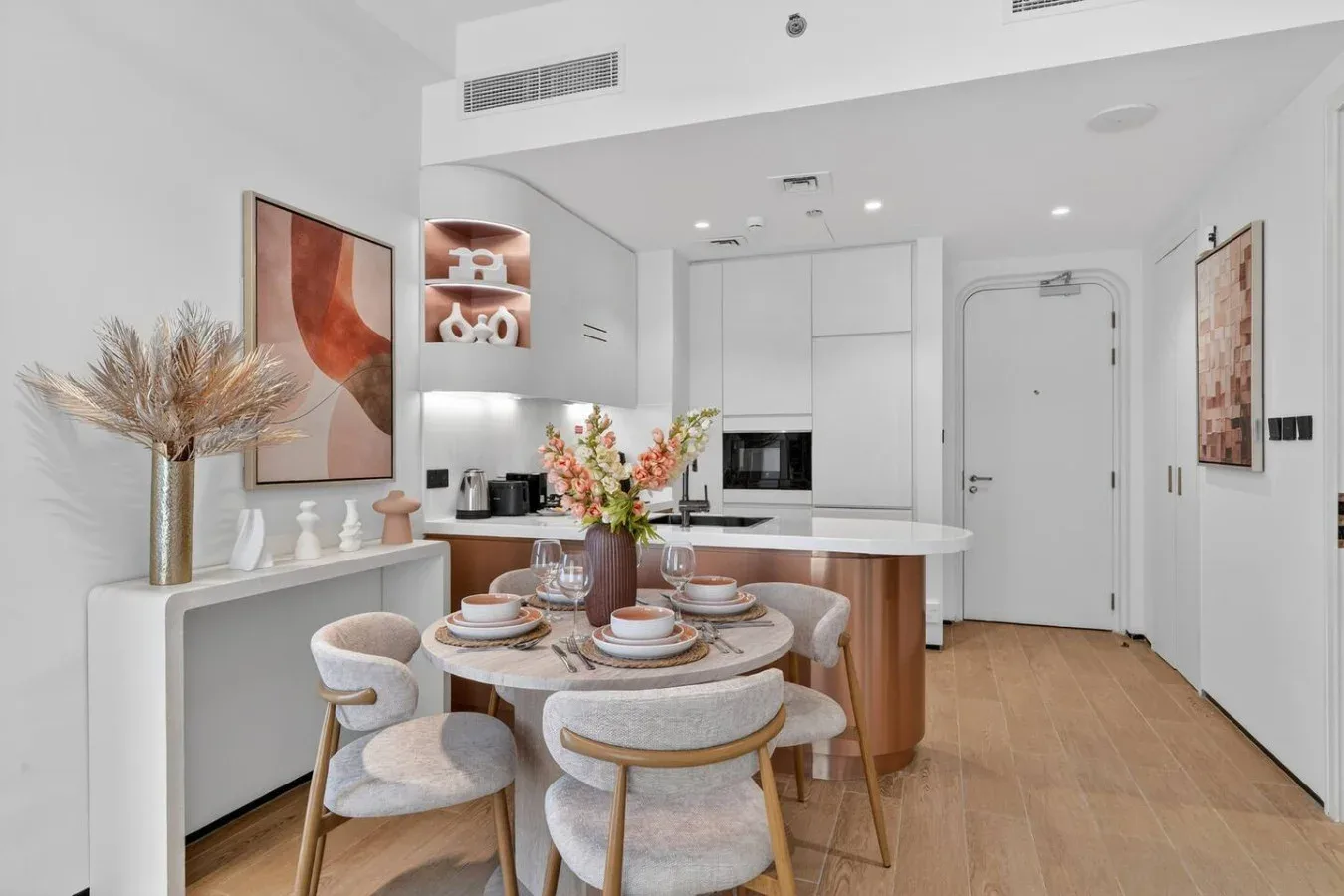 Comedor luminoso con una mesa redonda junto a una cocina moderna.