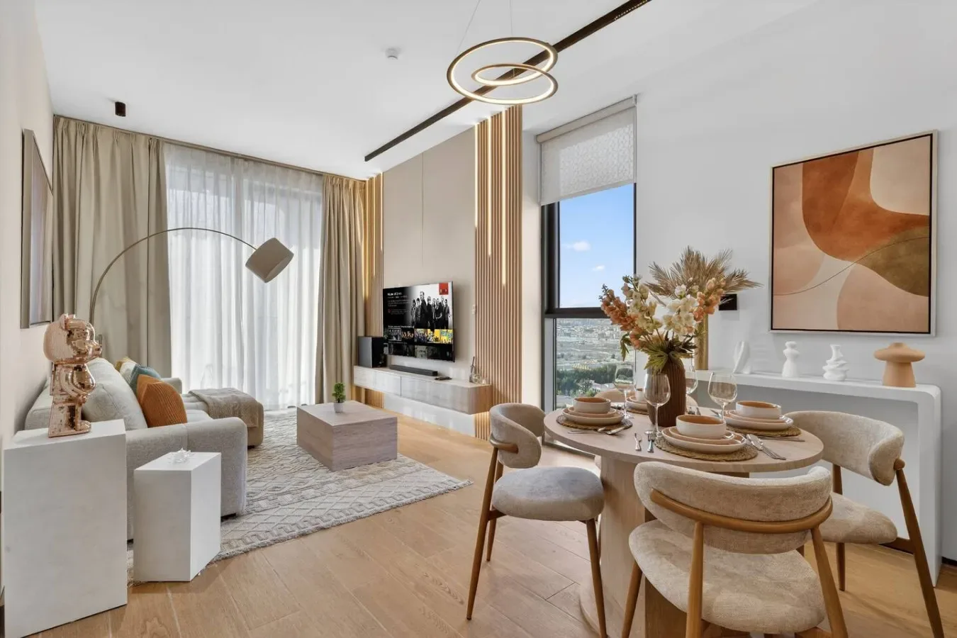 Una luminosa sala de estar y comedor, con una mesa junto a las ventanas.