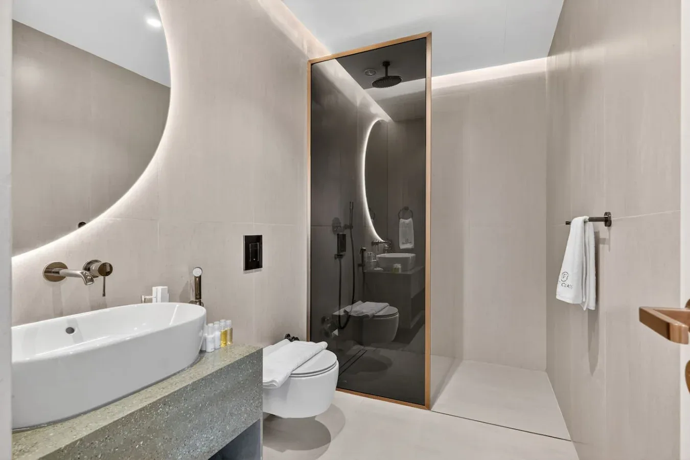 Un baño moderno con bañera, inodoro y ducha con mampara de vidrio.
