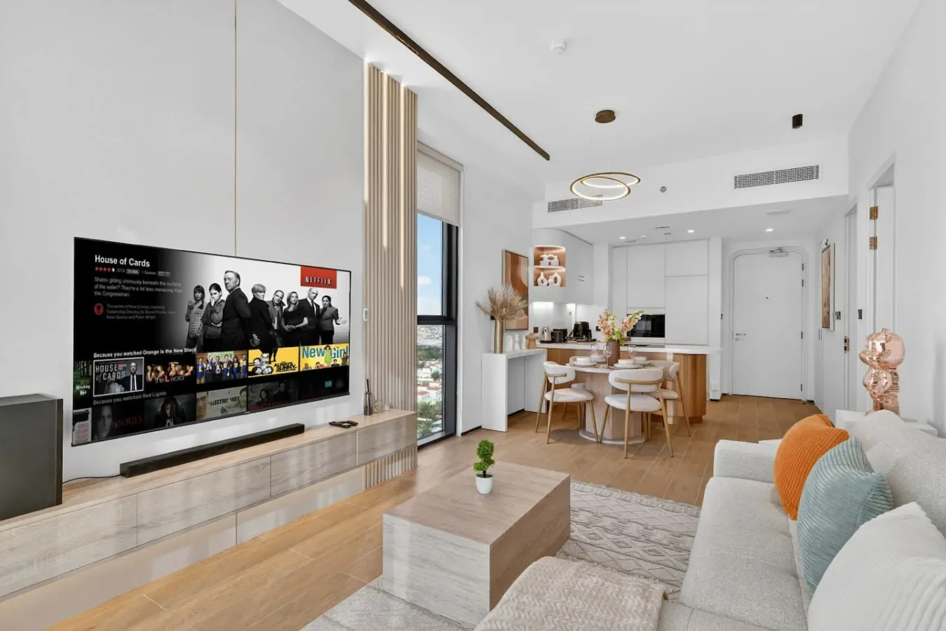 Un luminoso espacio diáfano con sala de estar, cocina y mesa de comedor.