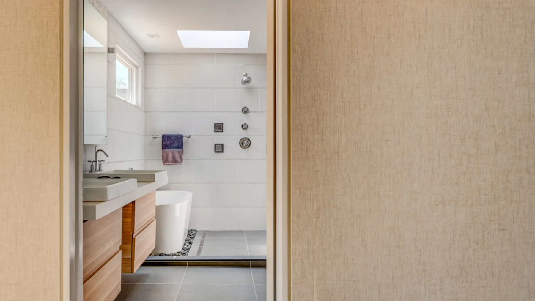 A bathroom with a sink, toilet, and tiled shower area.