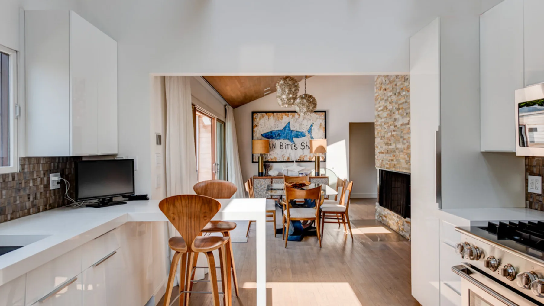 An open kitchen and dining area with a table and bar seating.