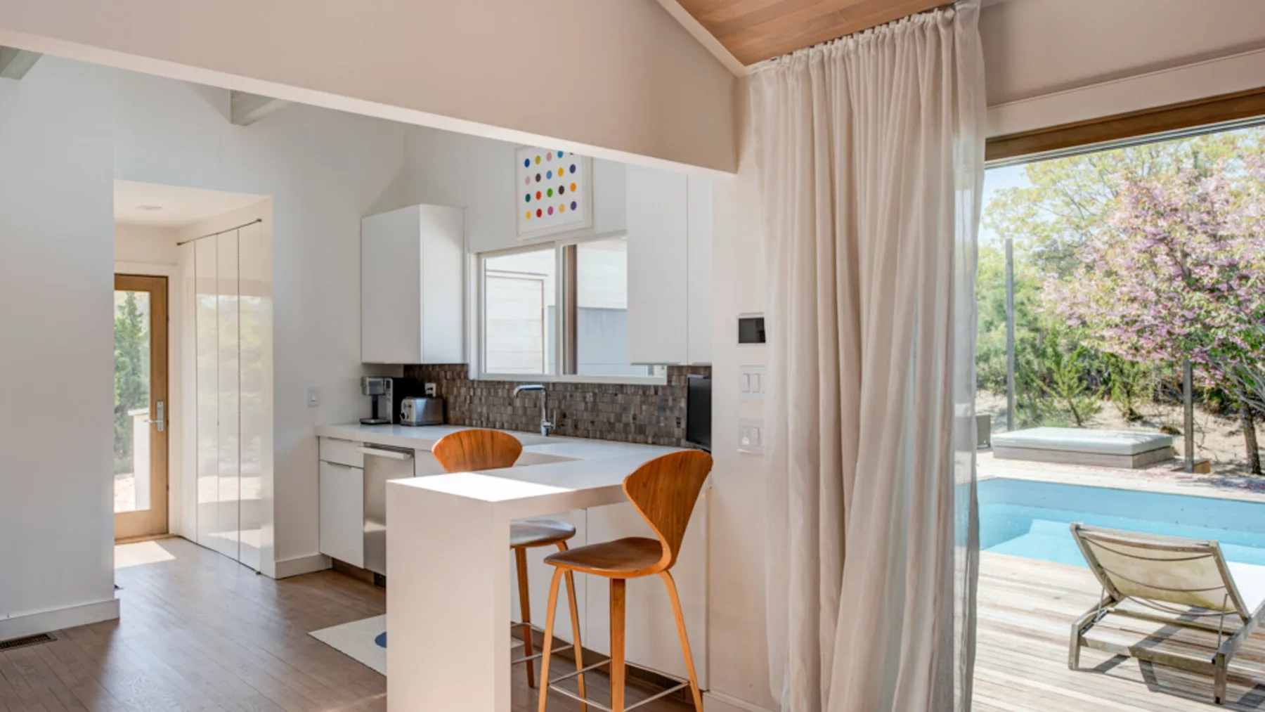 A bright kitchen with a central island and a view of the outdoor pool.
