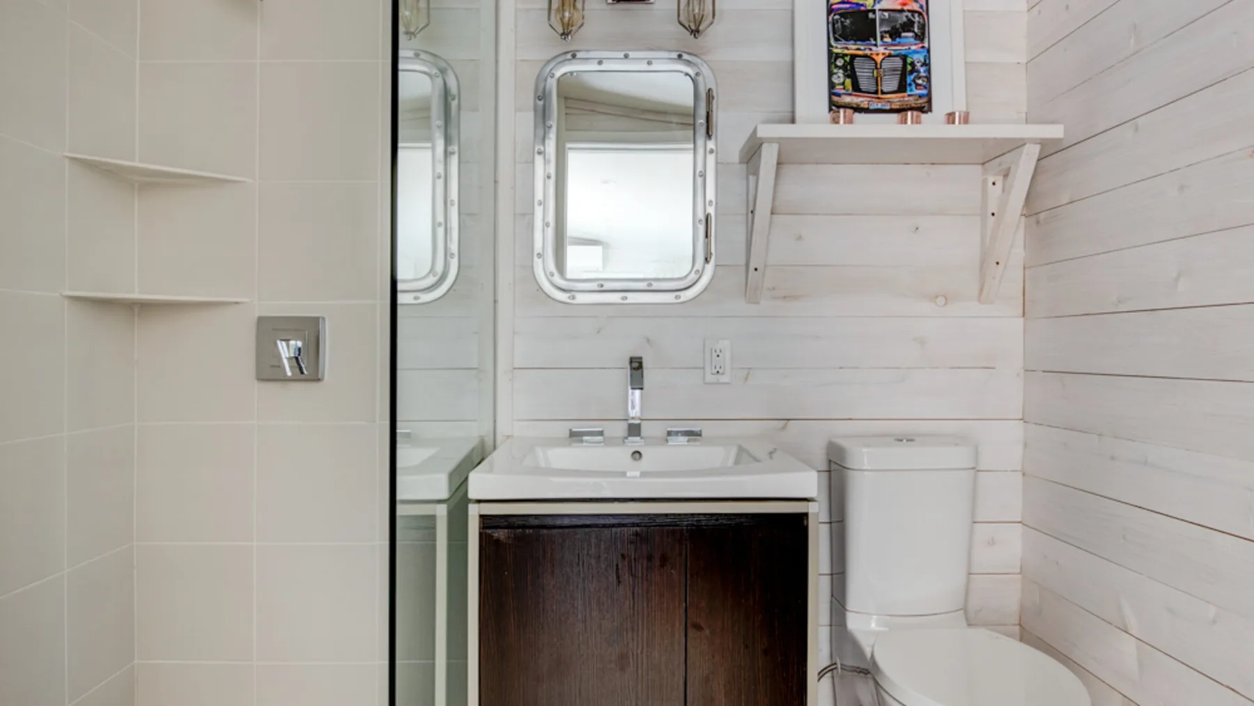 A bathroom with a sink, mirror, and toilet.