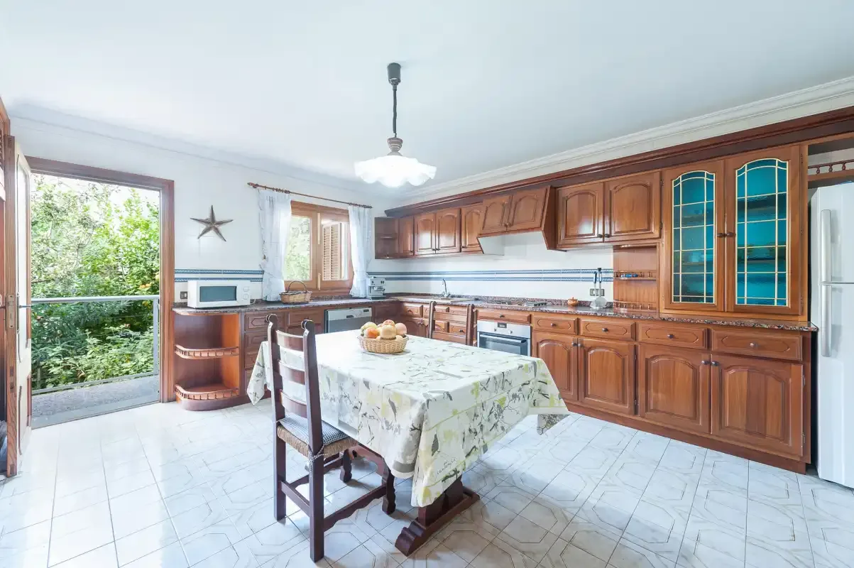 A bright kitchen with wooden cabinets and a dining table.