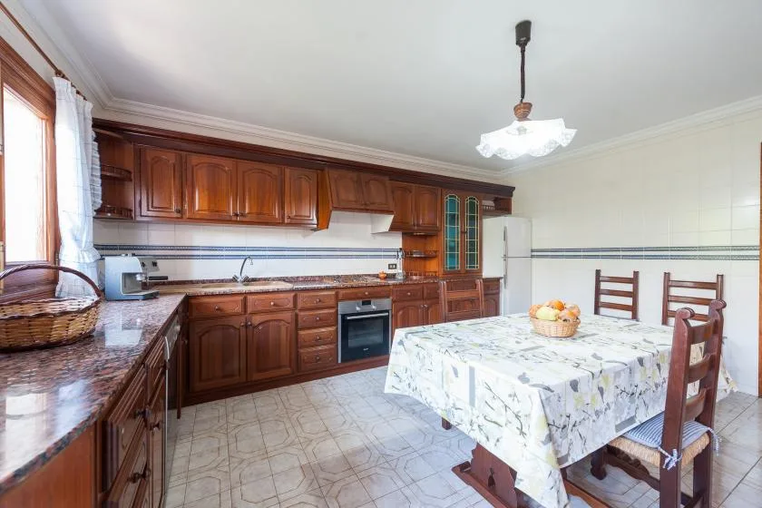 A kitchen and dining area with wooden cabinets and a table.