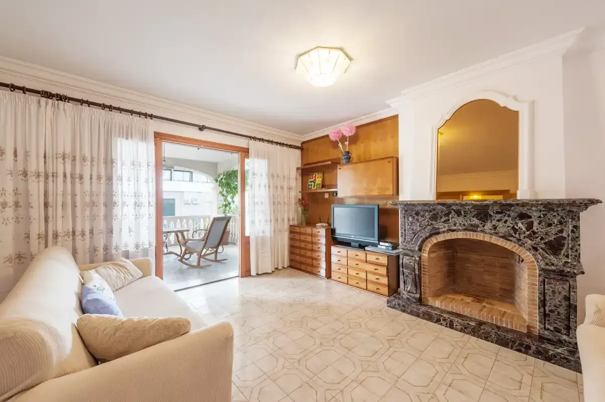 A living room with seating, a television, and a fireplace.