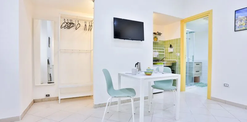 A bright room with a white table and chairs beside an open closet.