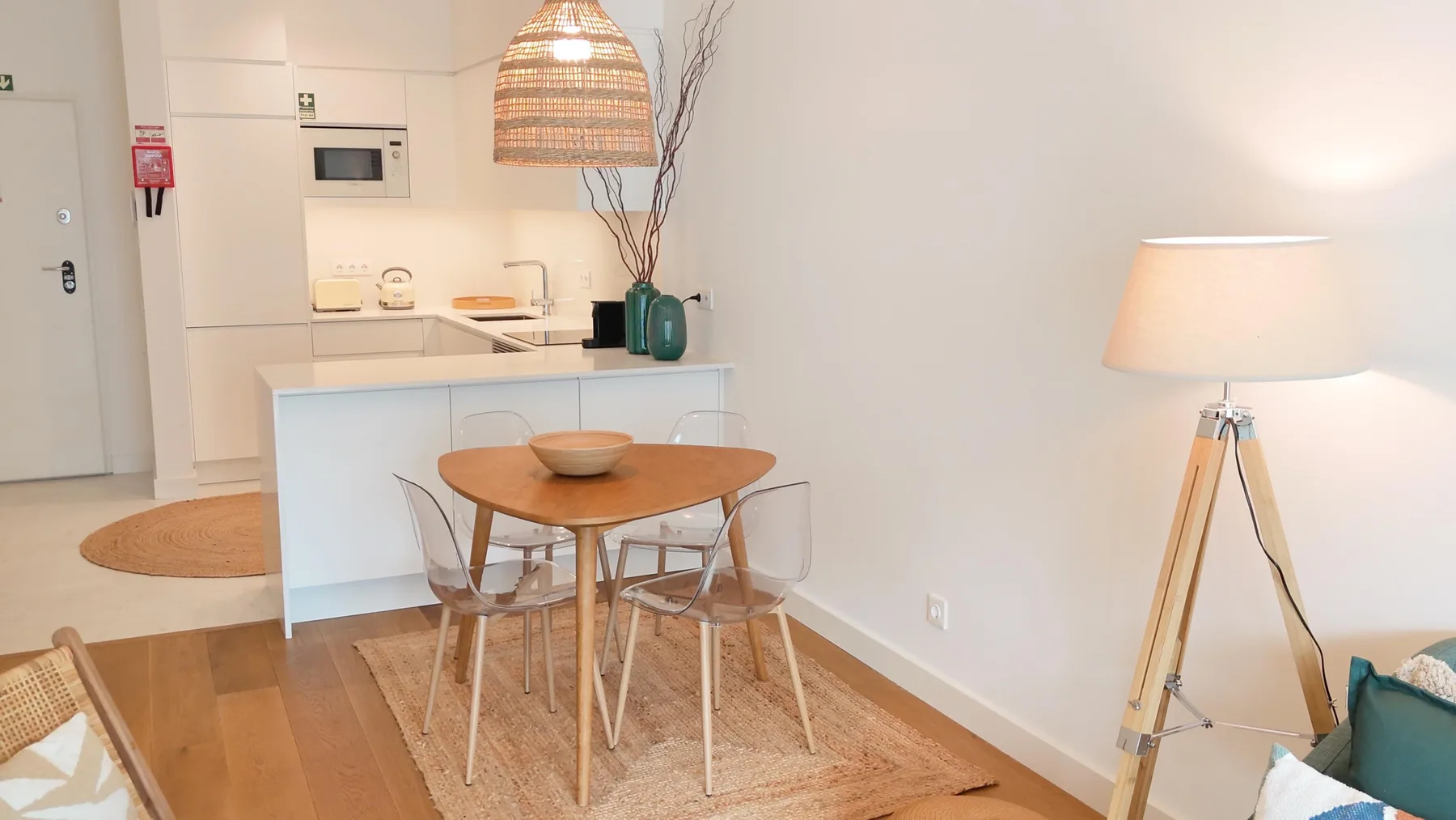 Un comedor luminoso con una mesa redonda junto a una cocina compacta.