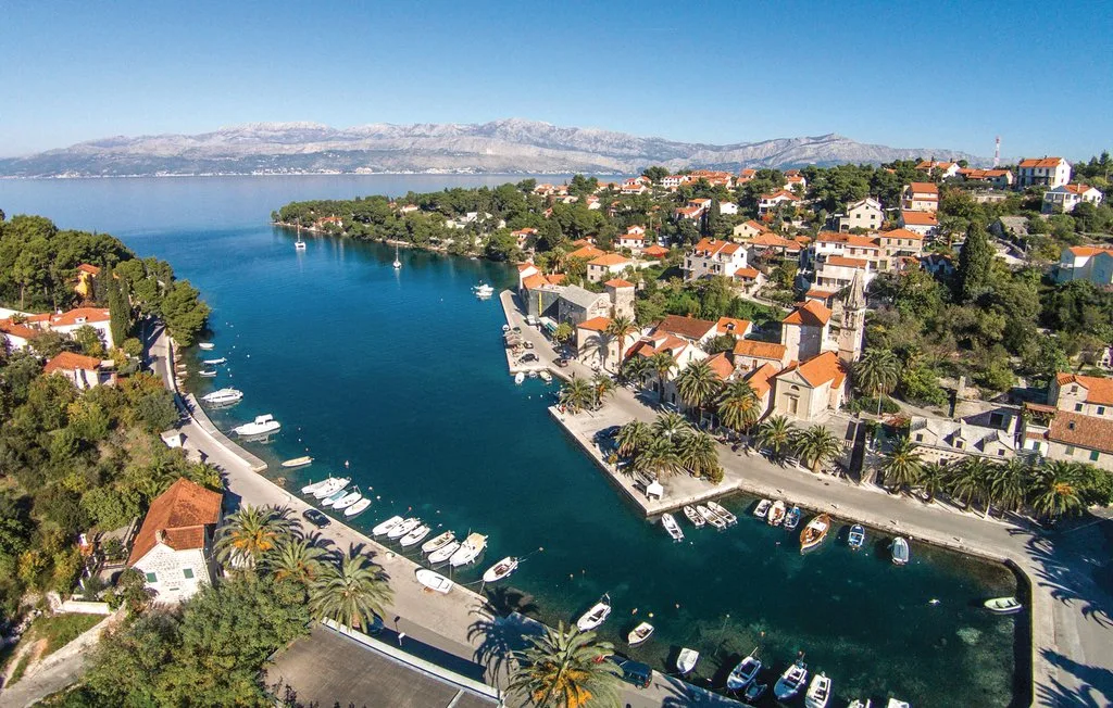 Aerial view of a coastal town around a harbor, with boats along the waterfront.
