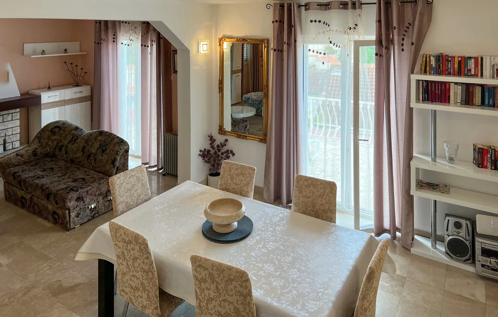 A dining area with a set table, upholstered seating, and a sofa nearby.
