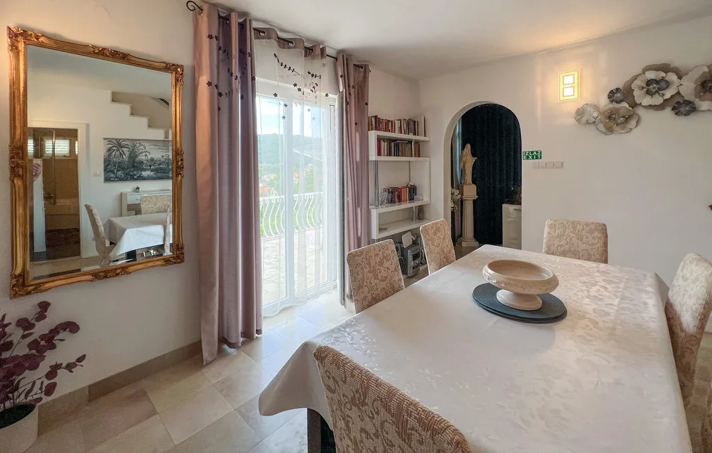 A dining area with a table, chairs, and a glass door to the balcony.