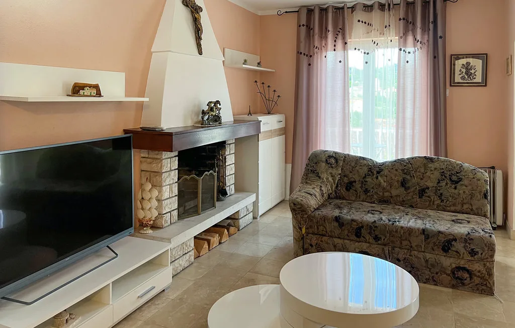 A living room with a television, fireplace, seating, and a round coffee table.
