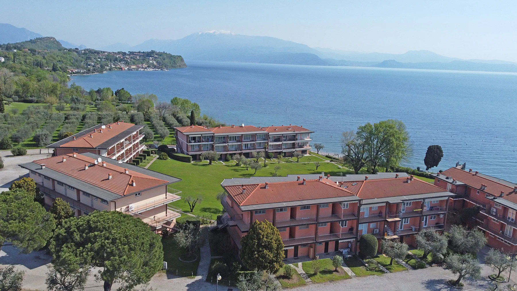A lakeside residential complex with red-roofed buildings and landscaped grounds.