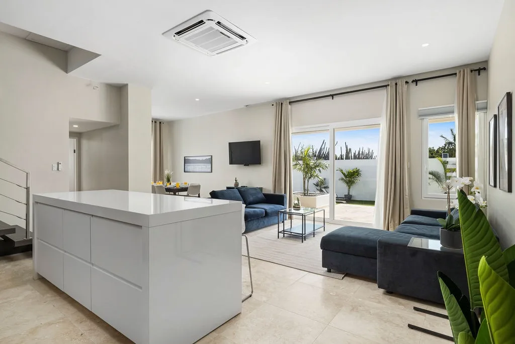 Settle into a sun-filled living space where sleek design meets relaxed comfort—your perfect spot to unwind with garden views just beyond the glass doors.