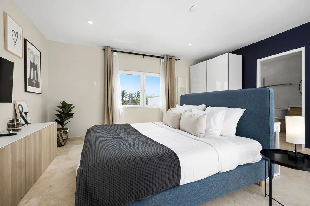 Sink into plush bedding and let natural light wake you gently in your serene bedroom retreat with modern style and thoughtful touches throughout.