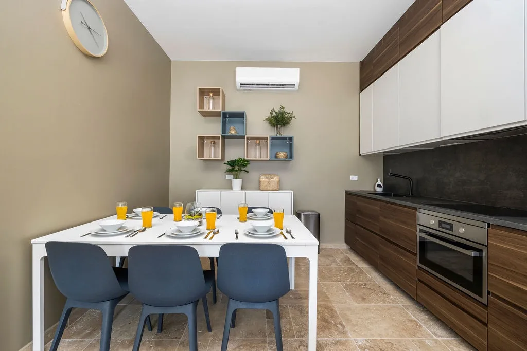 Picture yourself sharing meals in this modern dining space, where warm wood tones meet sleek design. The table is set and ready for your arrival, with fresh juice waiting to welcome you.