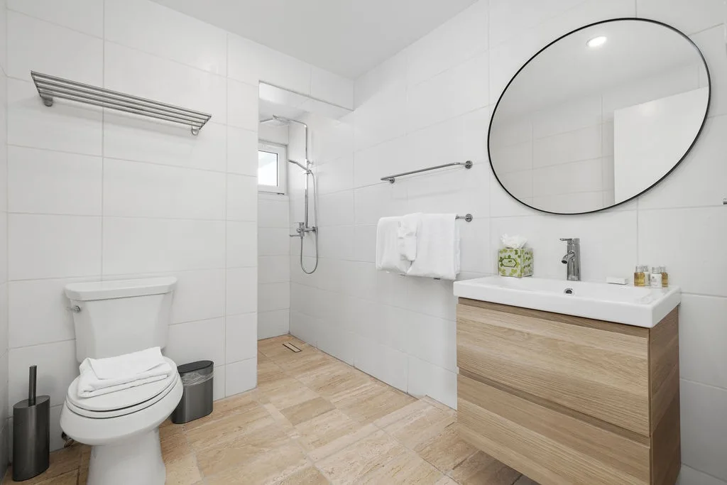 Your private bathroom features a walk-in shower, sleek vanity, and modern fixtures—designed for comfort and ease during your stay.