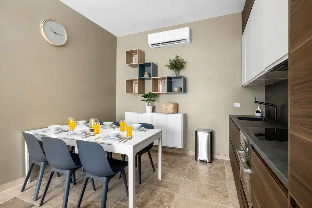 Your open-plan dining area and modern kitchen await—sunlight streaming in, sleek appliances ready, and room for six at the table to share morning coffee or evening meals together.