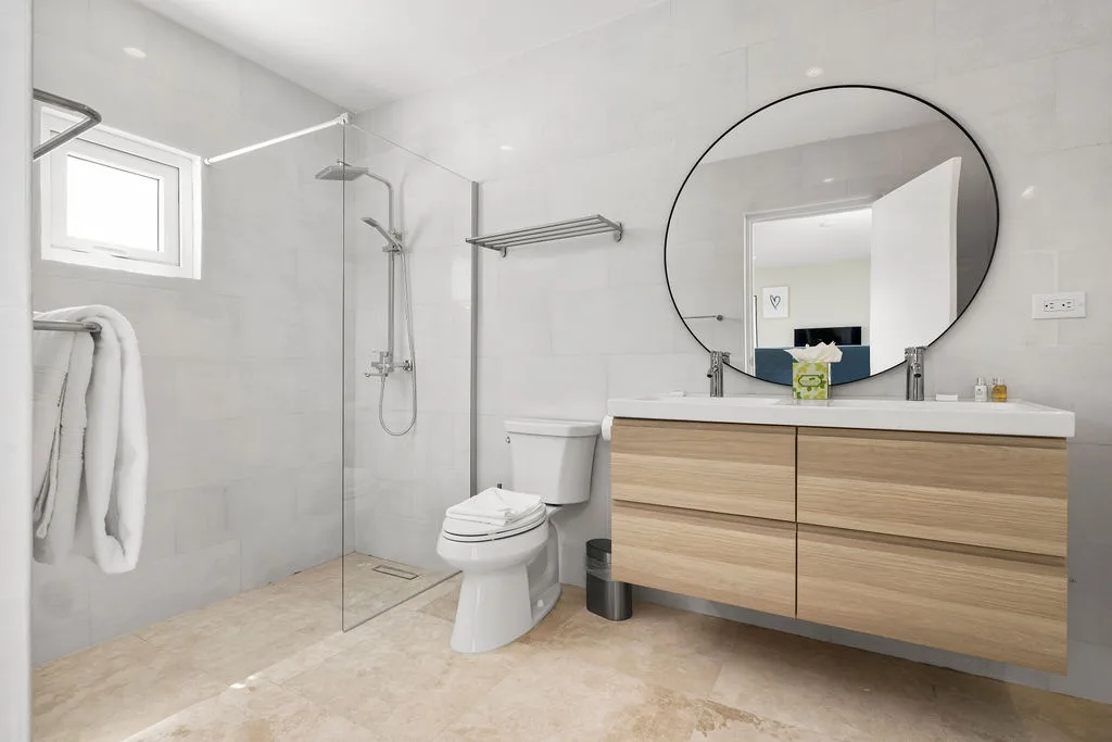 You'll love the modern, spa-like bathroom with a spacious walk-in shower, sleek wood vanity, and plenty of natural light to start your mornings refreshed.
