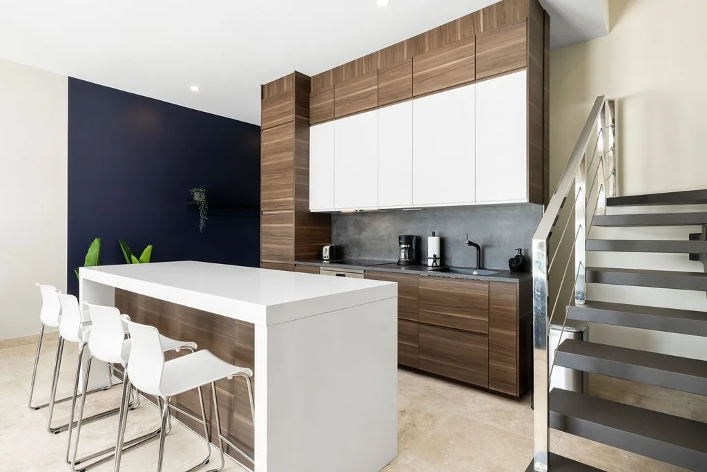 Your sleek modern kitchen features warm wood cabinetry, stone countertops, and a spacious island perfect for morning coffee or casual meals with loved ones.