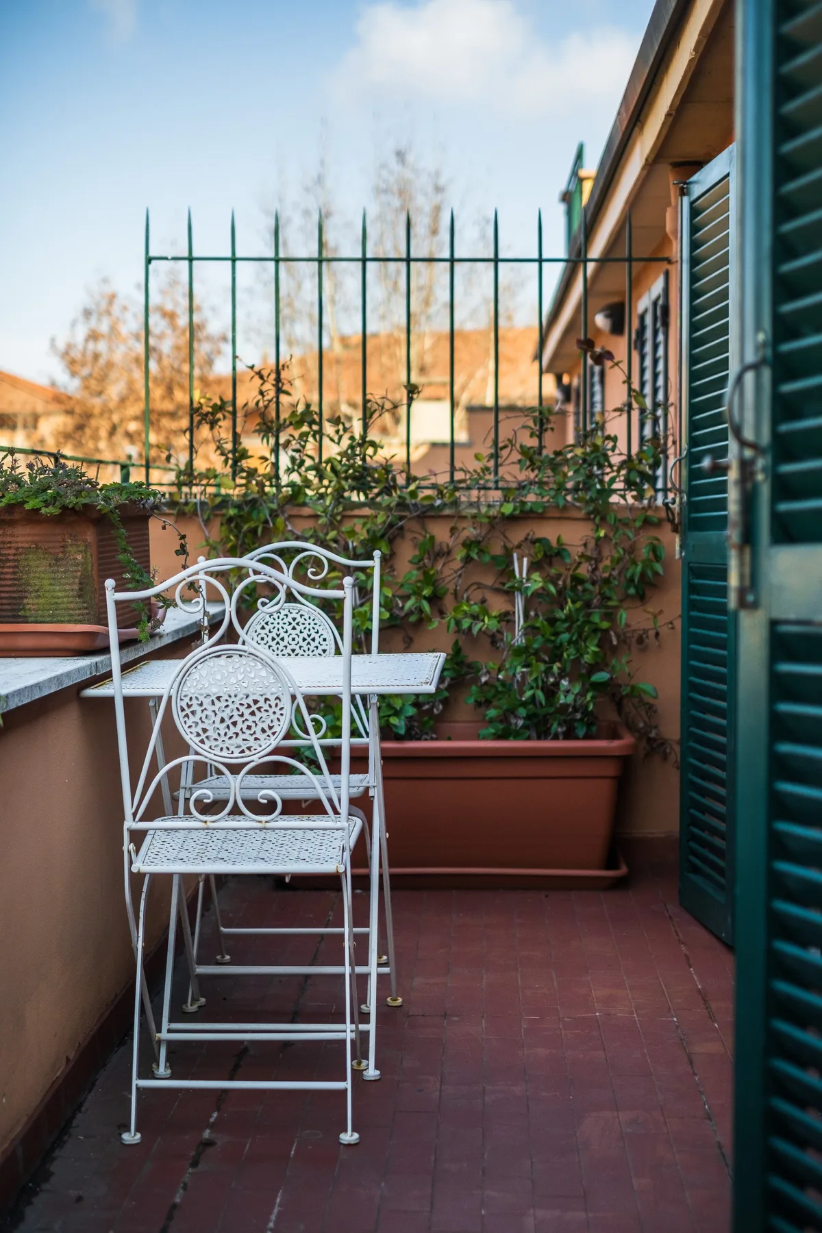 A small terrace with metal seating and planters along the wall.