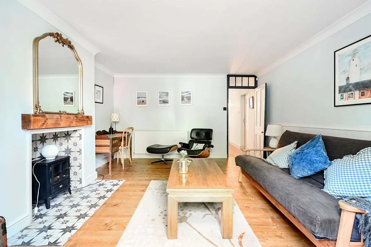 Una sala luminosa con un sofá gris y una mesa de centro de madera.