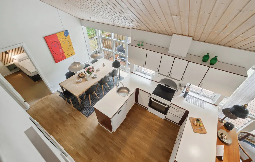 Una cocina abierta con zona de comedor, una amplia encimera y ventanas.
