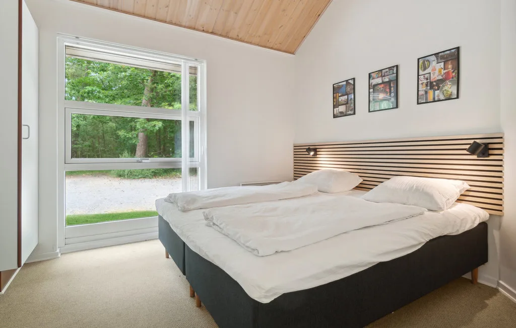 Un dormitorio con dos camas bajo un techo de madera inclinado.