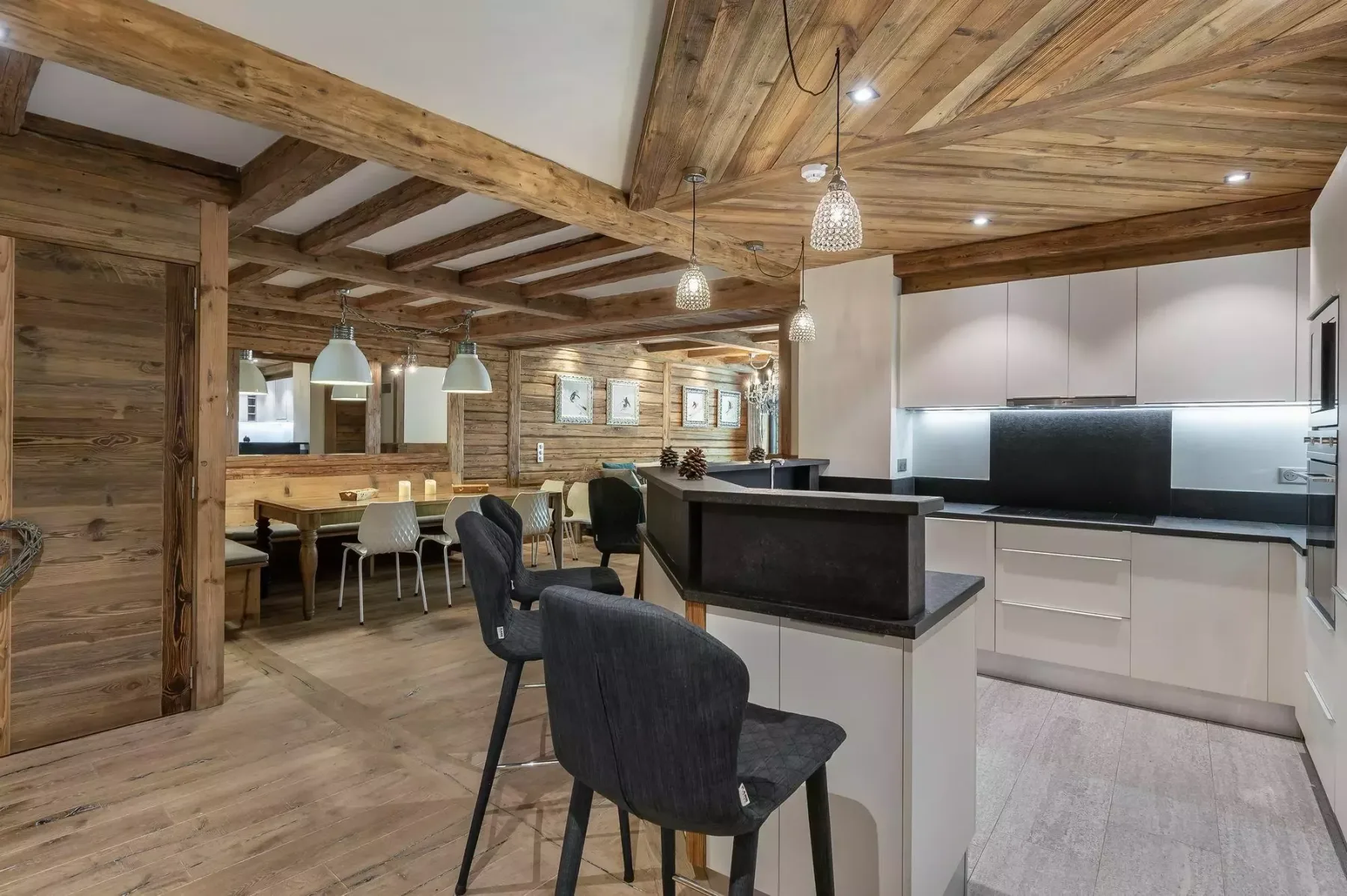 Una cocina y comedor de estilo rústico con una isla central y lámparas colgantes.